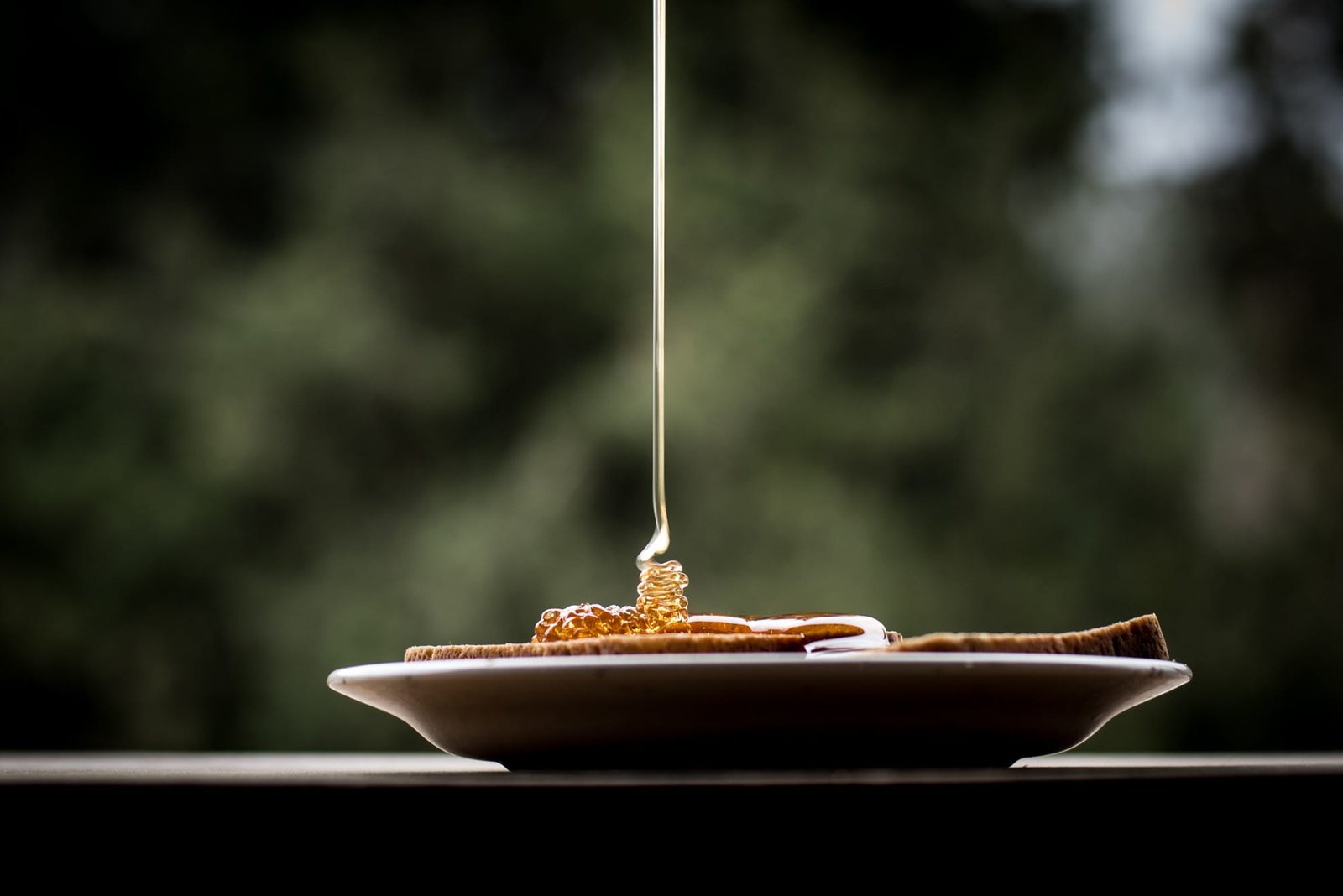 Hot honey drizzled over pizza with a golden glow