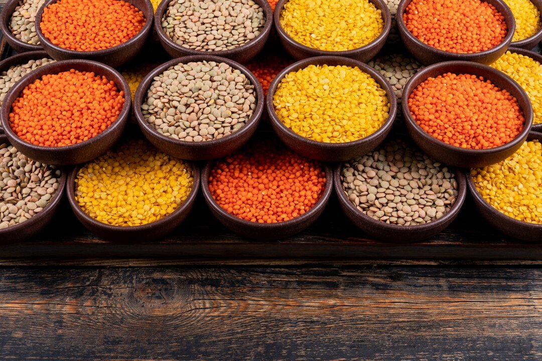 Variety of lentils in bowls with spices and herbs