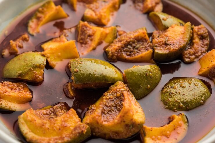 Traditional mango pickle in a glass jar with spices